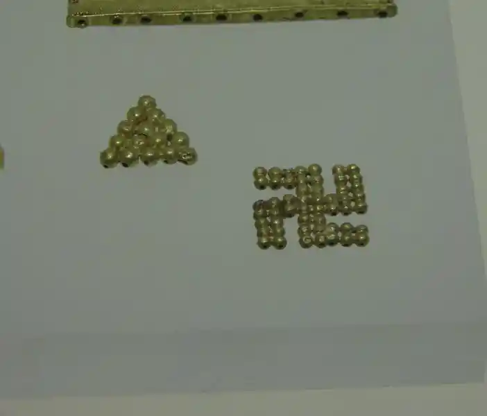 Small spheres forming a triangle and swastika.